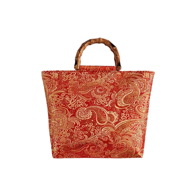 Red and gold patterned tote bag with a bamboo handle on a white background