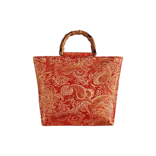 Red and gold patterned tote bag with a bamboo handle on a white background