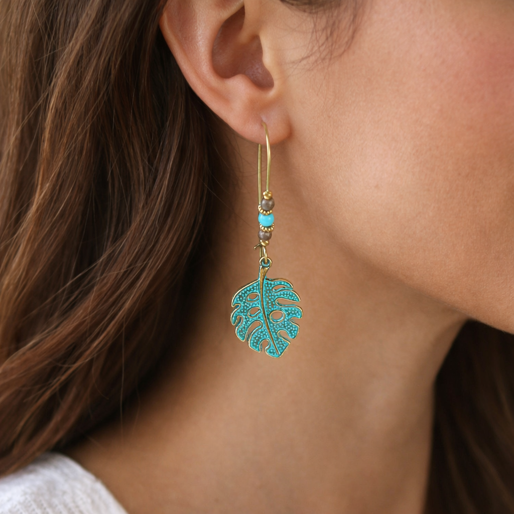 Close-up of a person wearing turquoise leaf-shaped earrings.