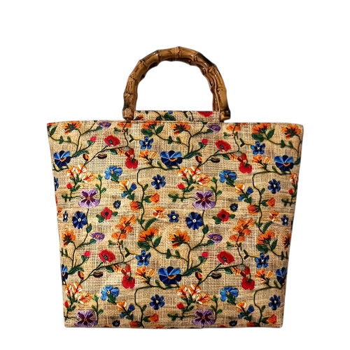 Floral embroidered jute bag with wooden handle on a white background