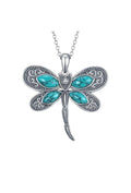 Dragonfly-shaped pendant with turquoise stones on a white background